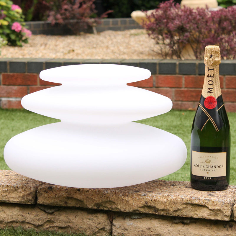 A spiral shaped outdoor lamp, 25 cm high, next to a champagne bottle