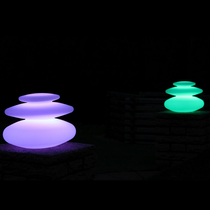 Two spiral mood lamps, set to purple and green, at night